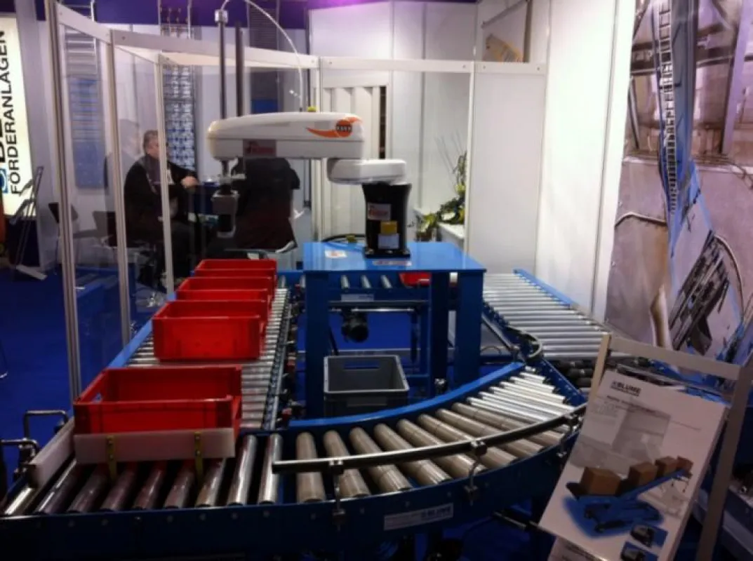 BLUME-ROLLEN zeigt auf der CeMAT 2011 auch eine Behälterförderanlage mit integriertem Handhabungsroboter