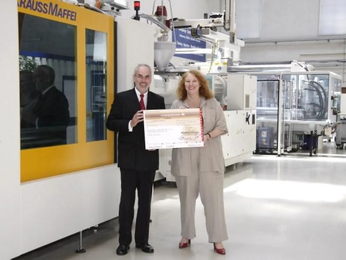 Josef Märtl, Vorsitzender der Geschäftsführung Krauss-Maffei, übergibt den Scheck in Höhe von 5.000 Euro an Petra Windisch, Vorstand Deutsche Lebensbrücke e.V.