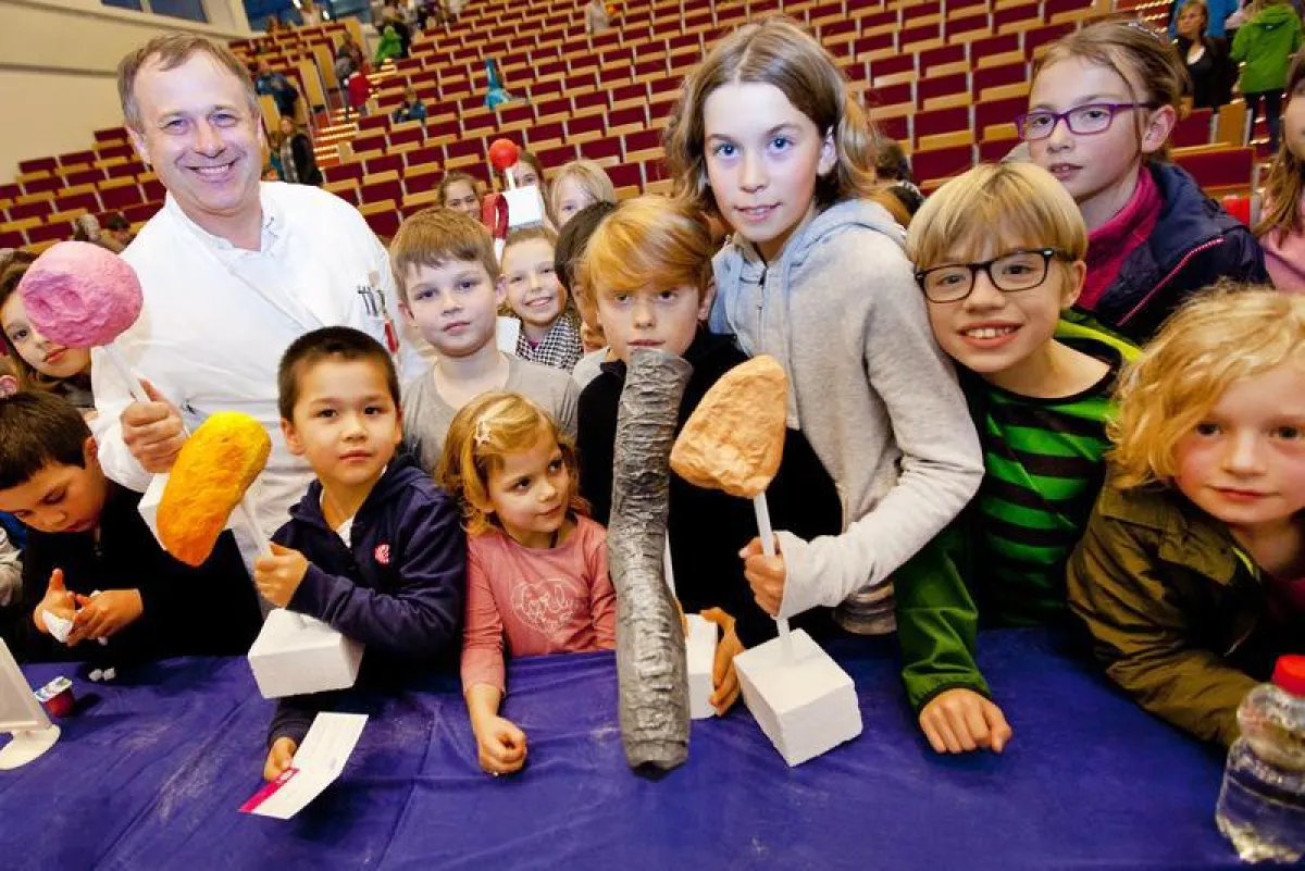 Dr. Stefan Stolle, der jungen Studierenden der KinderUniHannover Nasenmodelle zeigt. (