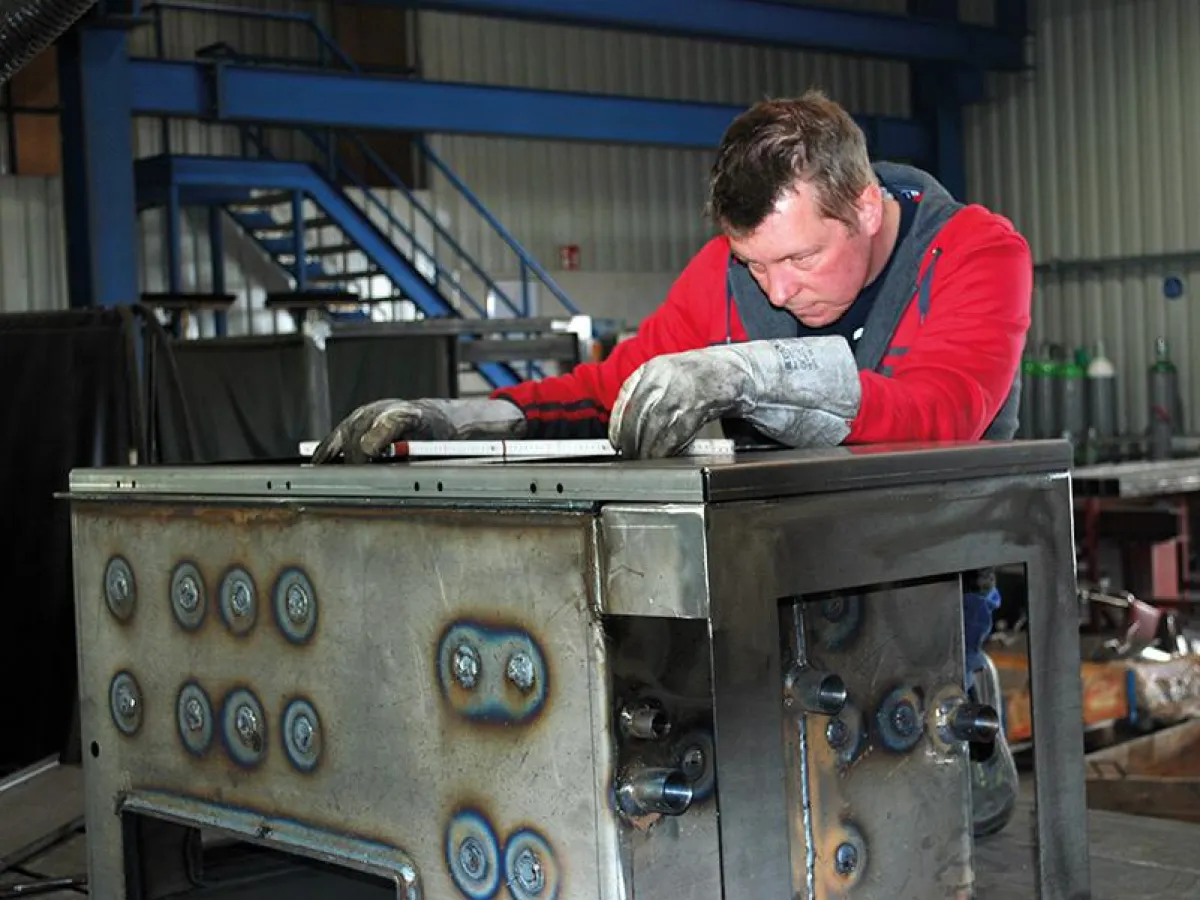 Konstruktion des e-Kaminofens. Björn Rußbült (Konstruktionsingenieur) im Labor ©Foto: HE Energy GmbH