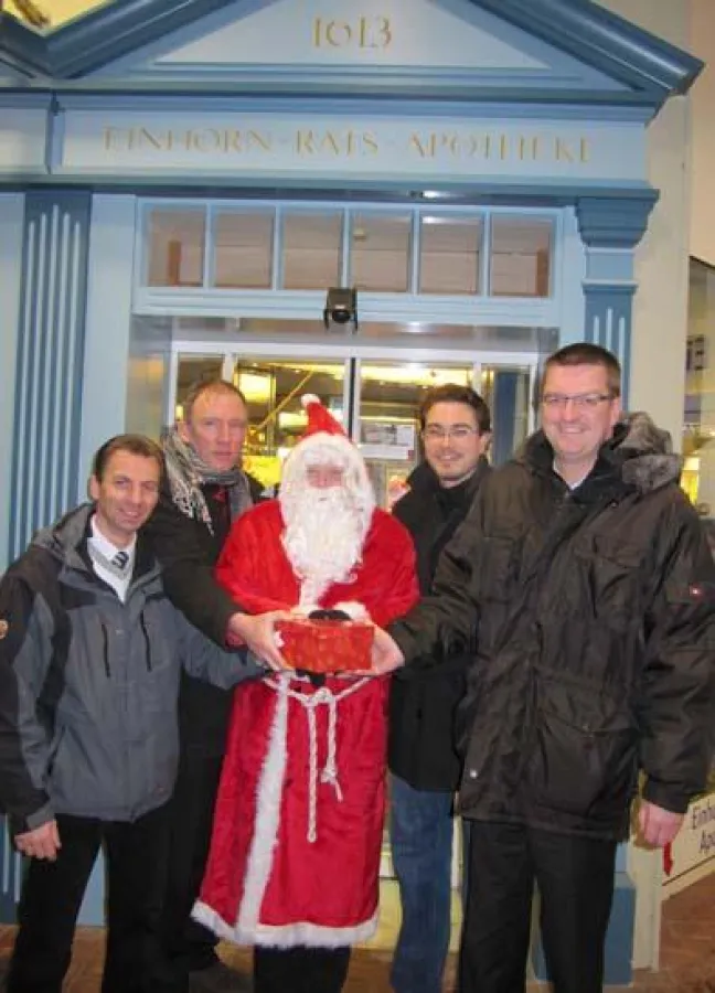 Matthias Schnupa, Thomas Huckfeldt, Weihnachtsmann Sönke Henningsen und Mogens Klatt übergeben Oliver Ridder die Spendengelder.