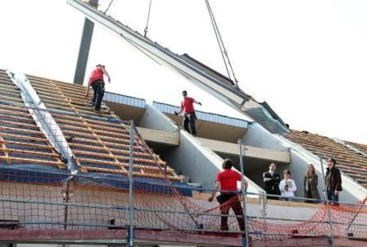 Zimmermänner vor dem Anbringen des Dachelementes des Hauses 141 m² Familienglück.