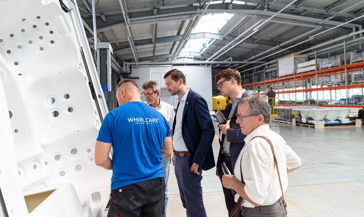 MdL Daniel Karrais (Mitte) mit Otmar Knoll (dahinter) beim Rundgang durch die Whirlcare-Produktion.