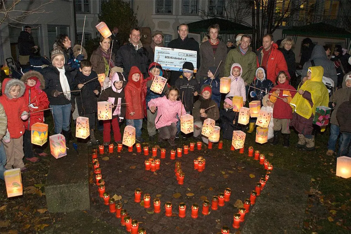 Volker Reeh, Mitglied der Geschäftsführung von Apollo-Optik, und Thomas Laker von SOS-Kinderdorf e.V. mit den Prominenten Tommy Krappweis, Beni Weber, Philipp Brammer und Max Felder sowie den kleinen 
