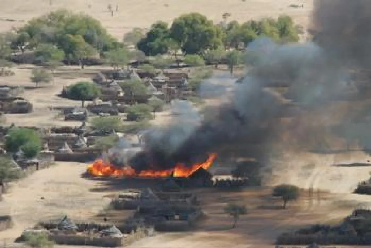 Brennendes Dorf in Darfur - Standbild aus dem Dokumentarfilm \'The Devil Came on Horseback\'