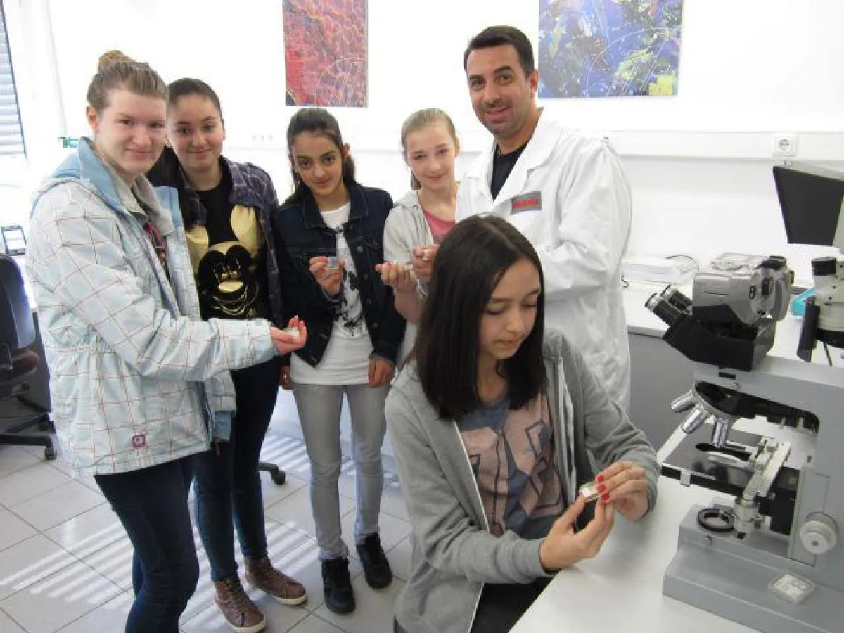 Ausbildungsleiter Konstantinos Pulios mit den Mädchen vom Girls´ Day im Labor.
