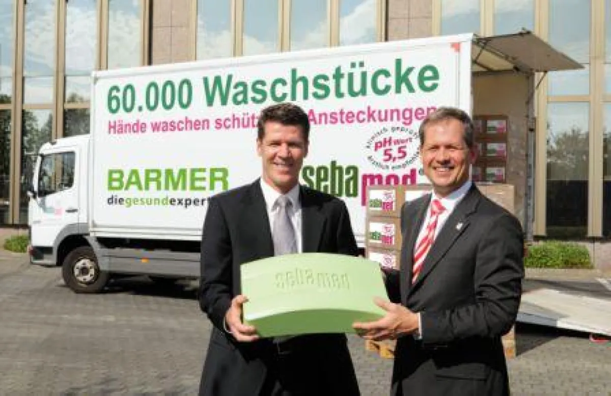 links: Heiner Beckmann (Leiter Marketing und Vertrieb BARMER), rechts: Udo Klüwer (Marketingleiter Sebapharma) bei der Übergabe der 60.000 sebamed Waschstücke in Wuppertal