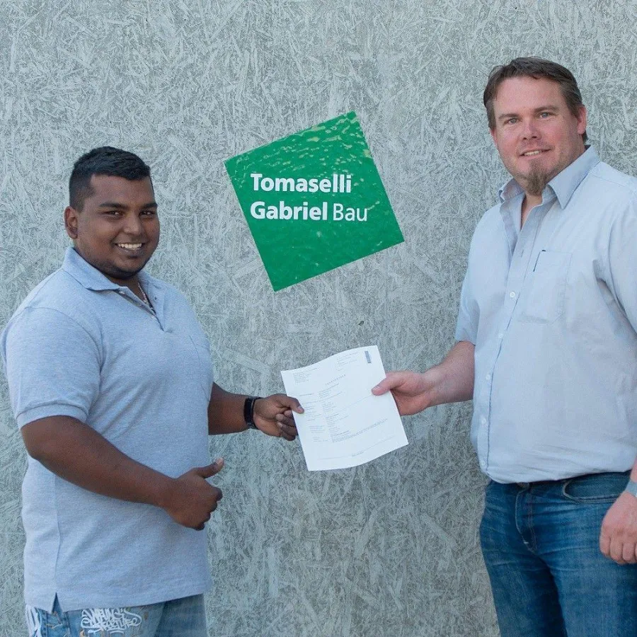 Suprean Leitner erhält seinen Lehrvertrag von seinem Ausbildner bei Tomaselli Gabriel Bau.