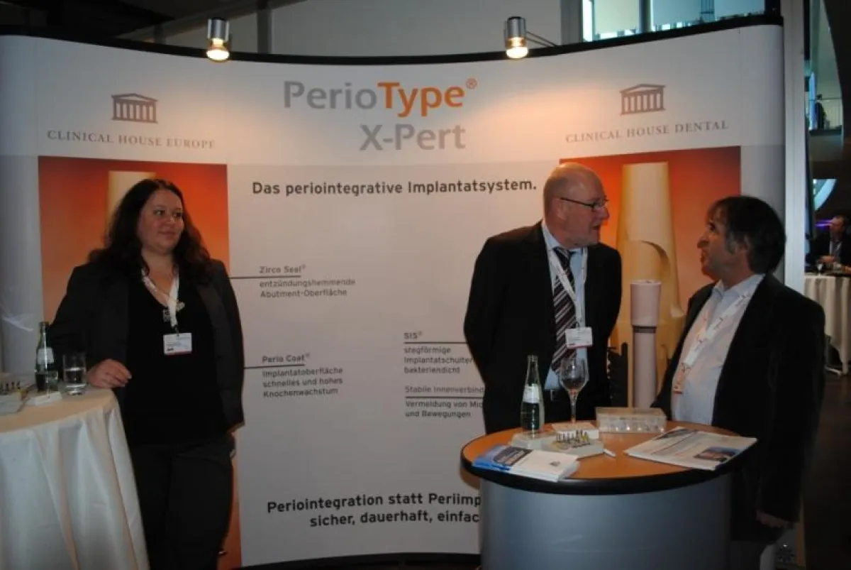 Sven Grether (Mitte), Geschäftsführer Clinical House Dental, am Messestand von Clinical House Dental