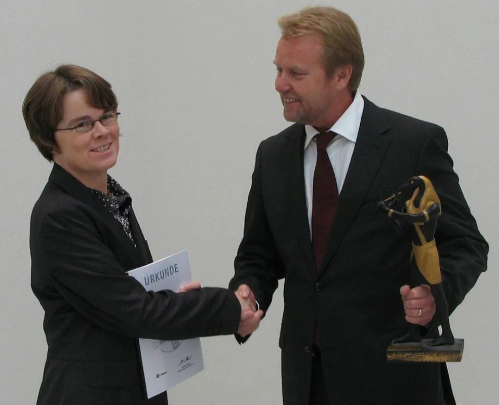 Claudia Riese, Technische Redakteurin bei der Tunstall GmbH, erhält den Dokupreis von Herbert Herzke, stellvertretender Vorsitzender der tekom e.V.