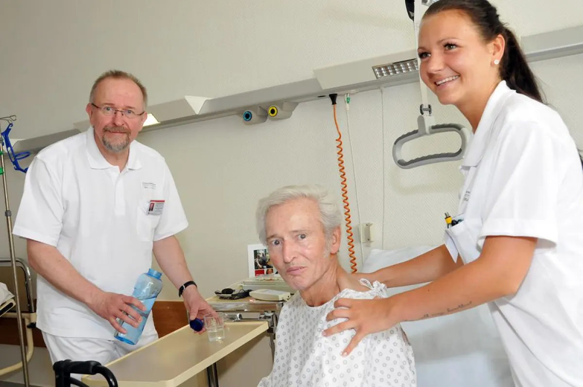 Axel Schäfer kümmert sich mit Krankenpflegerin Jessica Gargulinski um Siegfried Sawatzki.