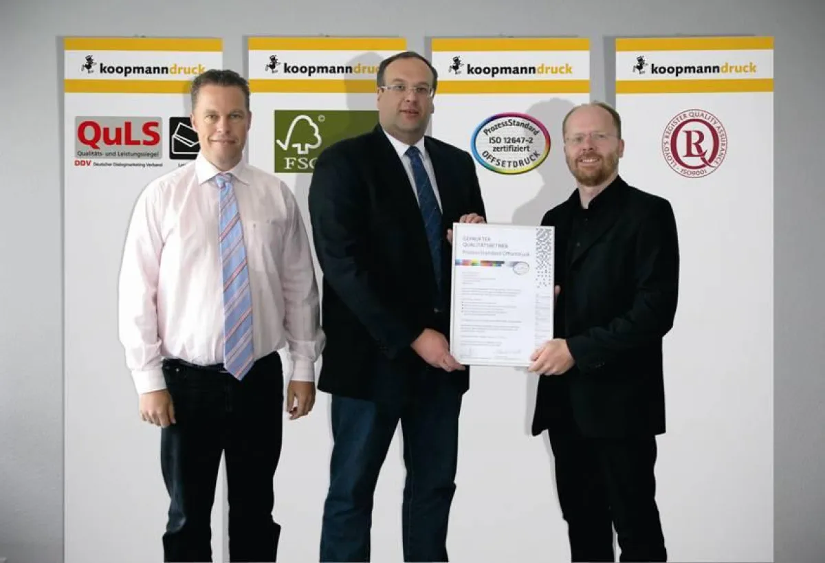 Oliver Gawryluk, Druckvorstufenleiter bei Koopmanndruck, zusammen mit Folker Neetzow, Prokurist bei Koopmanndruck, und Prüfer Udo Eickelpasch, Verband Druck und Medien Niedersachsen e.V.
