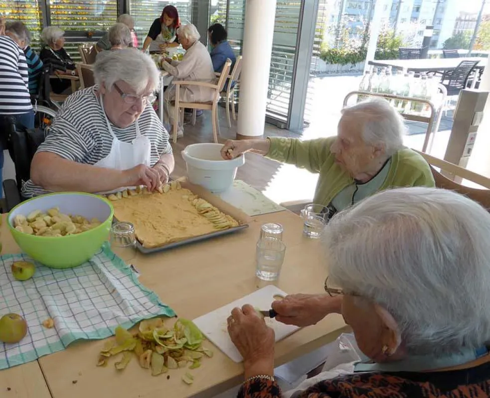 23 Bewohner des St. Marien Altenheims backten gemeinsam Apfelkuchen für Flüchtlinge in Monheim.