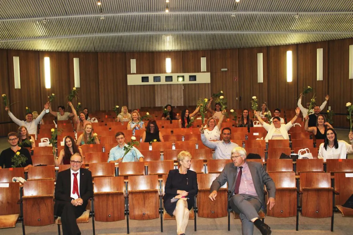 Strahlende Gesichter der frischgebackenen Altenpfleger/-innen trotz Abstand in der Aula