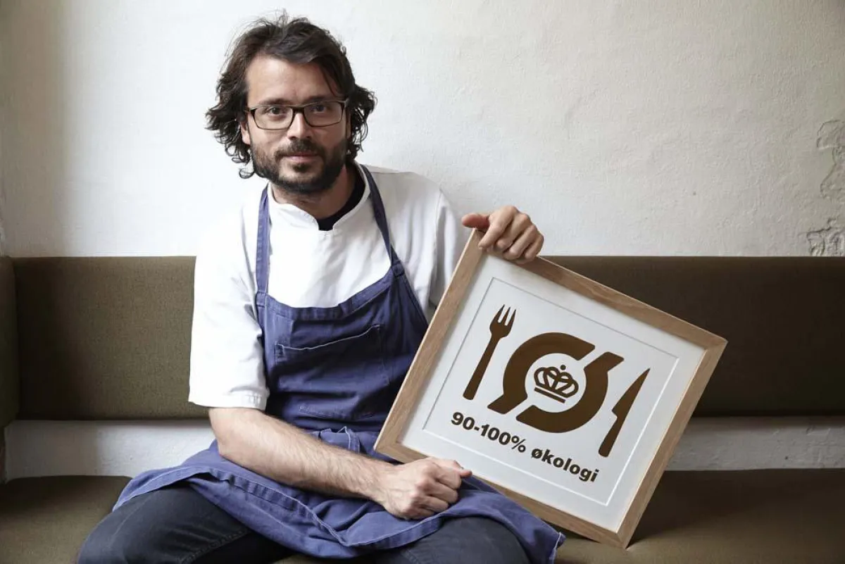 Chefkoch des Kopenhagener Sterne-Restaurants Relæ, Christian Puglisi, mit Bio-Siegel in Gold.