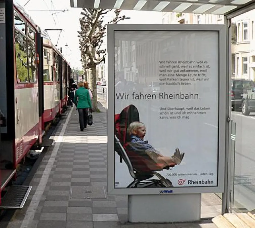 Die neue Plakataktion der Rheinbahn lacht von Düsseldorfer Haltestellen.