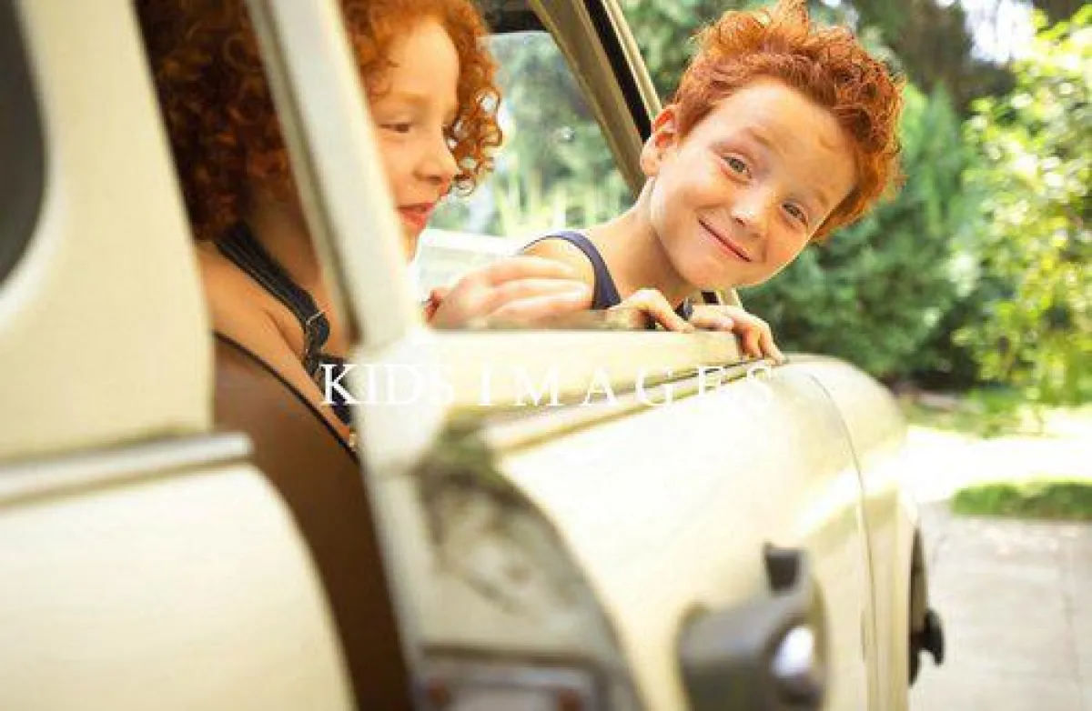 KIDS IMAGES - Rothaariger Junge im Auto