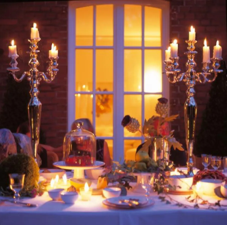 Einladend im wahrsten Sinne des Wortes und festlich zugleich wirkt die Tafel mit silbernen Kerzenständern in
