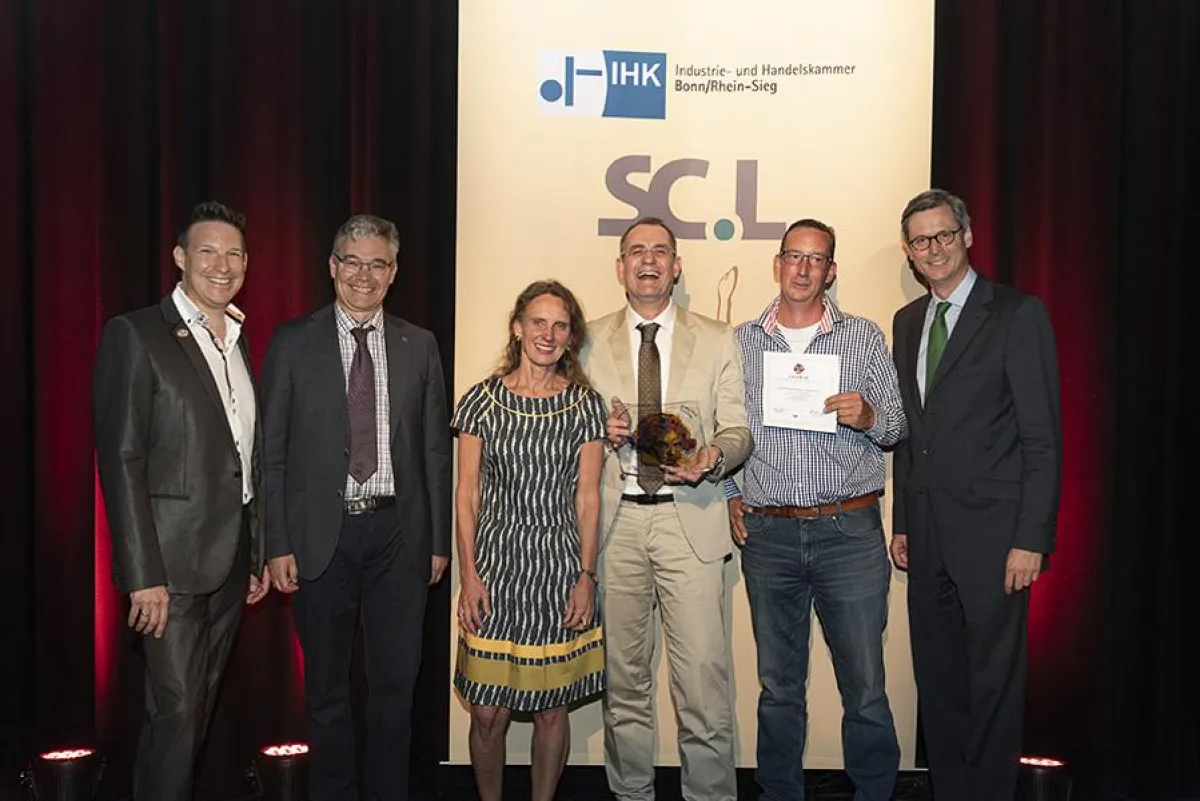 Bildunterschrift: Werner Vendel (m.) und Christian Schneider (2. v. r.) nehmen den Preis freudig an