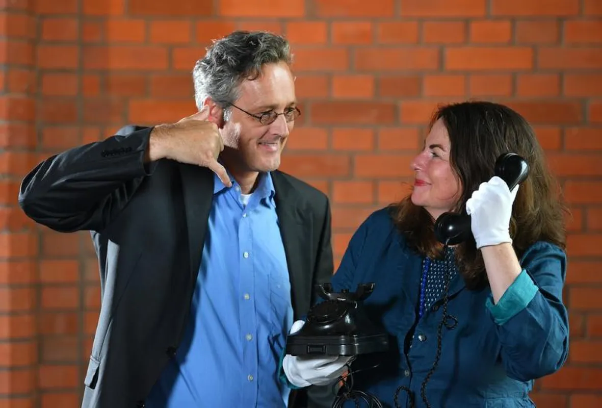 Die übliche Telefongeste wird nicht an zeitgenössischen Geräten angepasst, sondern bewahrt die Form alter Apparate. Im Bild: Museumsdirektor Dr. Oliver Brehm und Gestenforscherin Prof. Ellen Fricke.