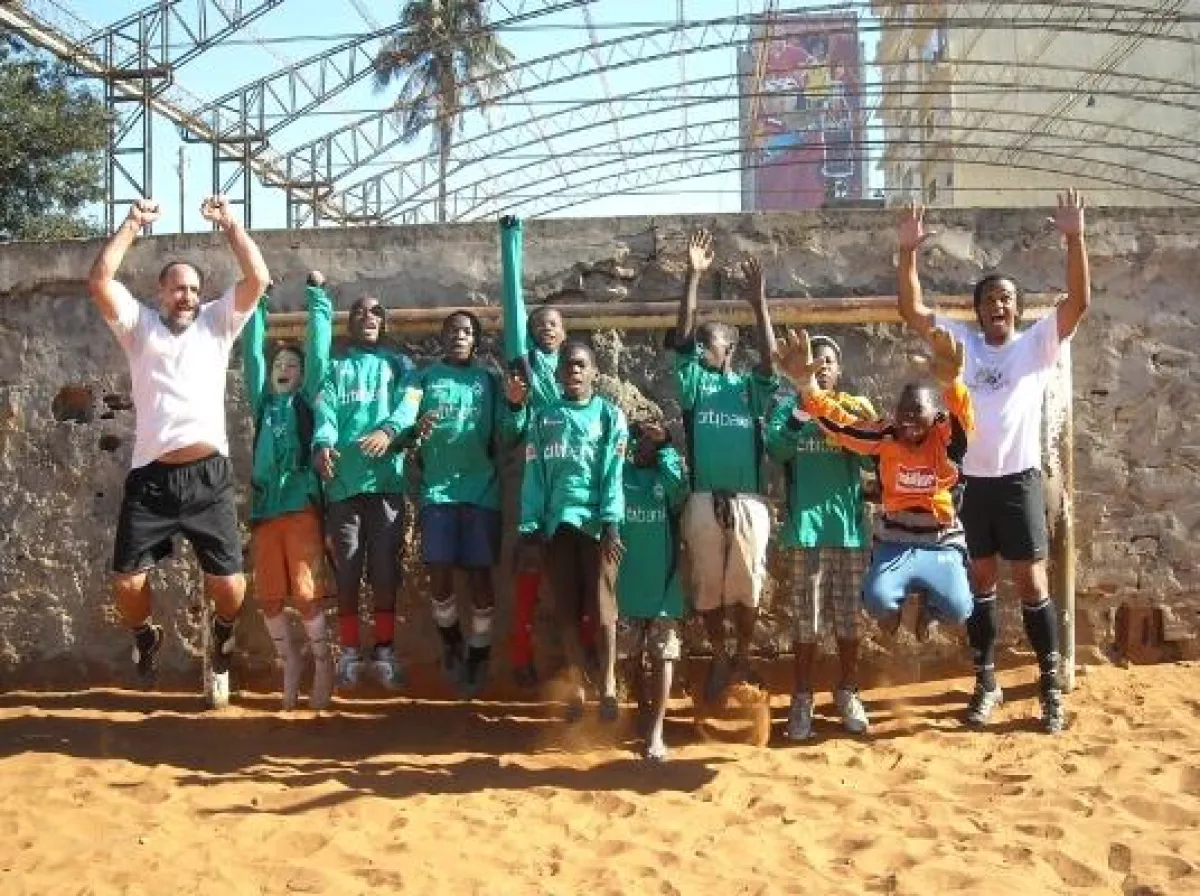 2schneidig in der Fußballschule in Maputo (Mosambik); die Kinder freuen sich über die Trikots