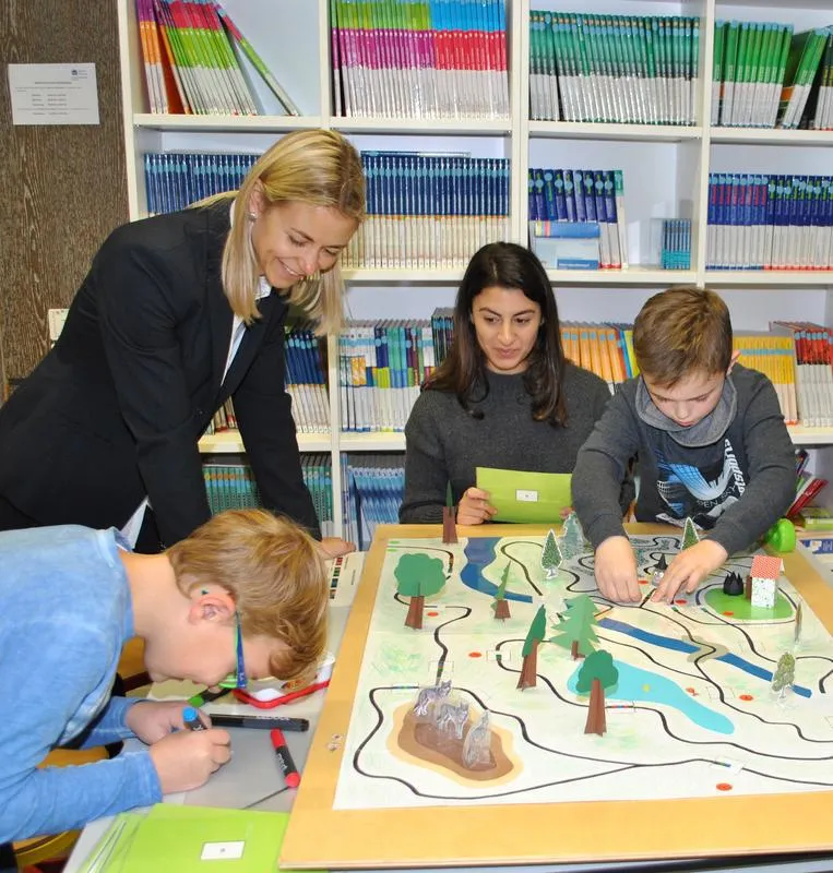 Viertklässler der Grundschule Heusweiler erproben eine der kleinen Lernwelten, die Lehramts-Studentinnen wie Saina Akhlaghi (Mitte) am Lehrstuhl von Silke Ladel (l.) an der Saar-Uni entwickelt haben.