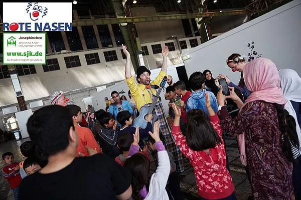 Bild: ROTE NASEN Clowns im Dienste der Gesundheit - spezielles Clownprogramm für Flüchtlinge in den Hangars