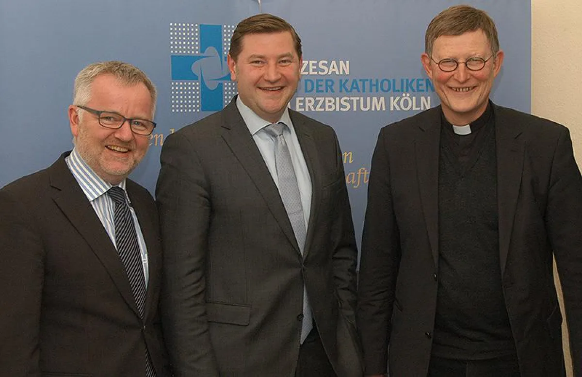 v.l. Vorstand Cornel Hüsch und Tim-O. Kurzbach, Erzbischof Rainer Maria Kardinal Woelki