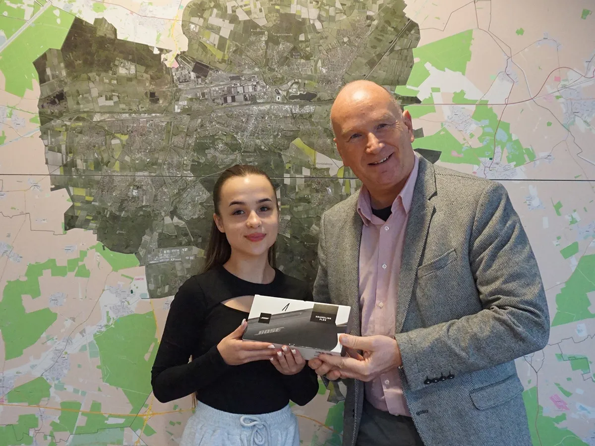 Frank Hitzschke (rechts) übergibt Liliia Vynohrad ihren Gewinn  (© WMG Wolfsburg)