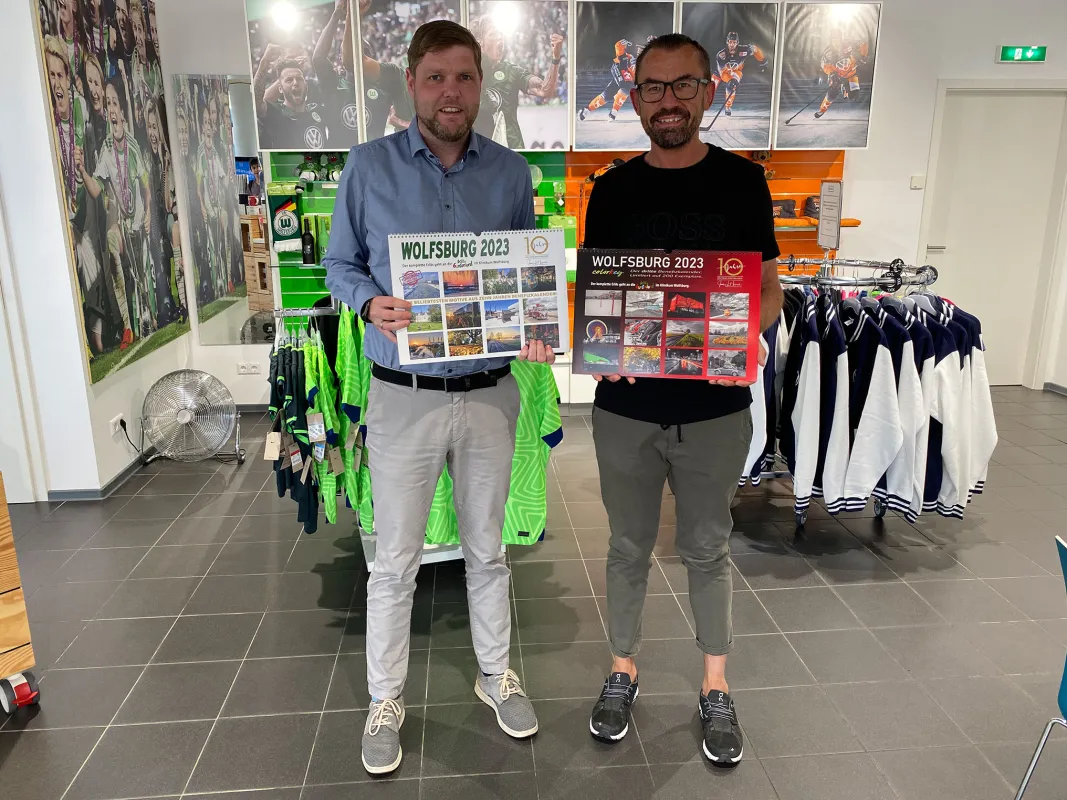 Christoph Kaufmann und Jens L. Heinrich präsentieren Wolfsburger Benefizkalender 2023 (© WMG Wolfsburg)