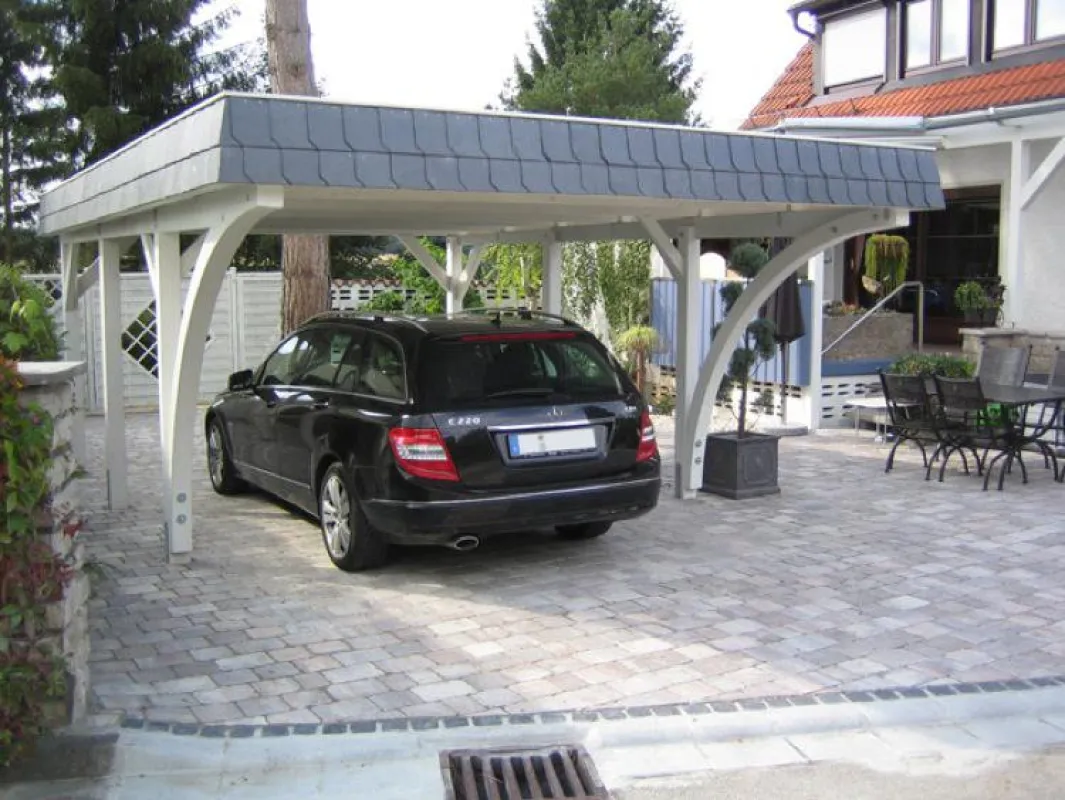 Einzelcarport aus Holz mit Leimholzbogen und Schieferblende.