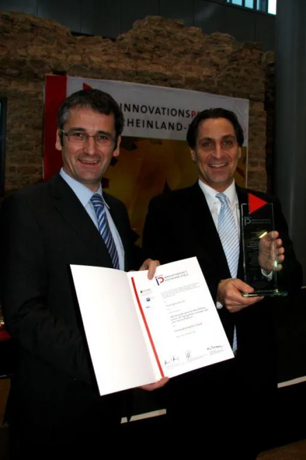 Der rheinland-pfälzische Wirtschaftsminister Hendrik Hering (links) übergibt Christoph Schwind, dem Geschäftsführenden Inhaber von meetingmasters.de, den Innovationspreis.