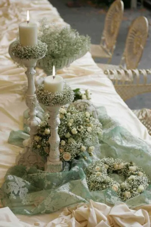 Weißes Schleierkraut, cremefarbene Rosenblüten und weiße, lackierte Kerzen mit dem RAL-Gütezeichen - so wird aus einem einfachen Tisch eine festliche Tafel!  Fotovermerk: Gütegemeinschaft Kerzen