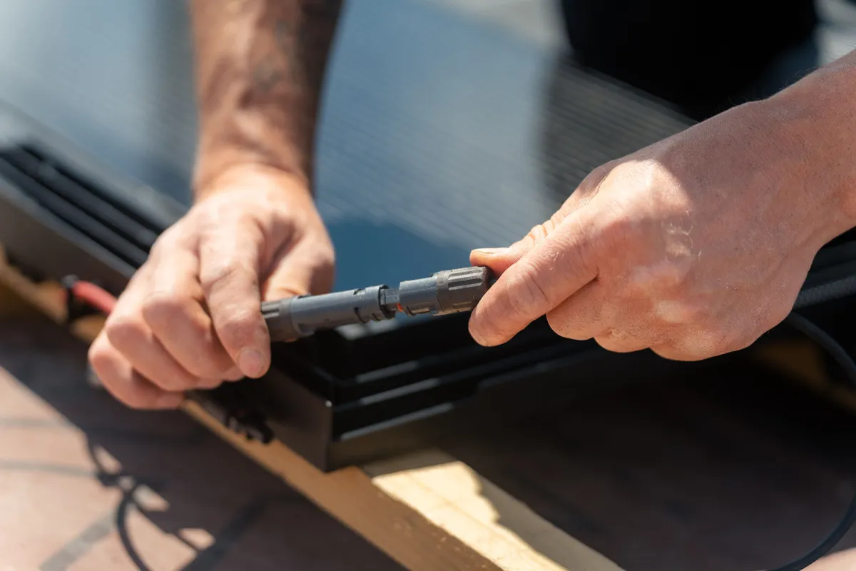 Die Steckerverbindungen werden am Modul des ERLUS Energiedachs eingeklickt. (© Foto: ERLUS AG, Fotograf: Bildcraftmedia Etienne Hausel.)