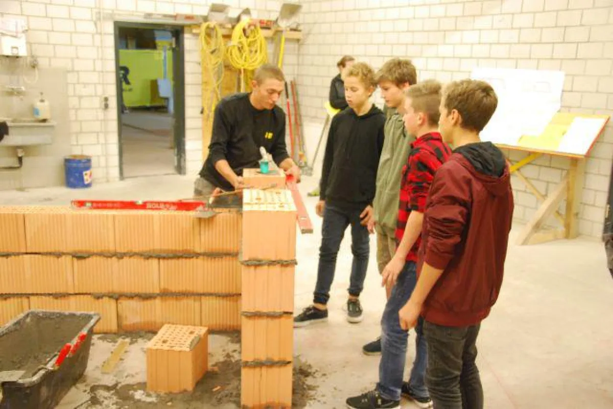 Vor den Augen der interessierten Jugendlichen zogen Maurer-Lehrlinge von i+R eine Ziegelwand hoch