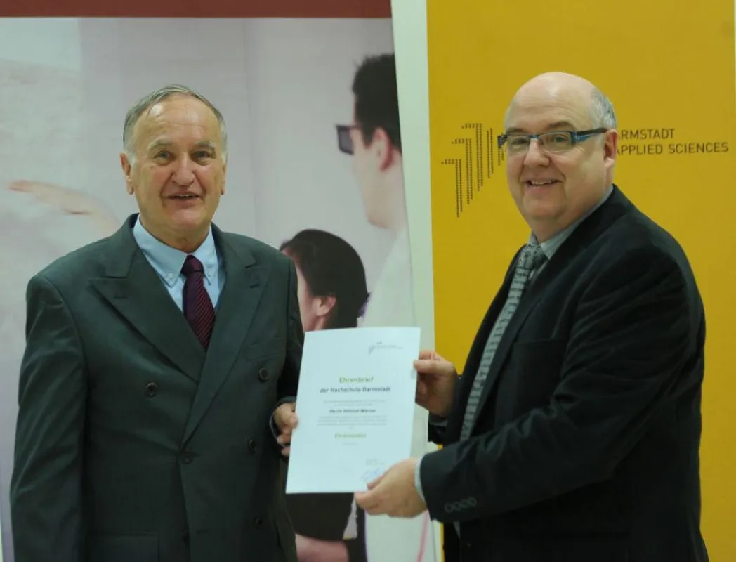 Präsident Prof. Dr. Stengler (r.) übergibt Wörner (l.) den Ehrenbrief der Hochschule Darmstadt.