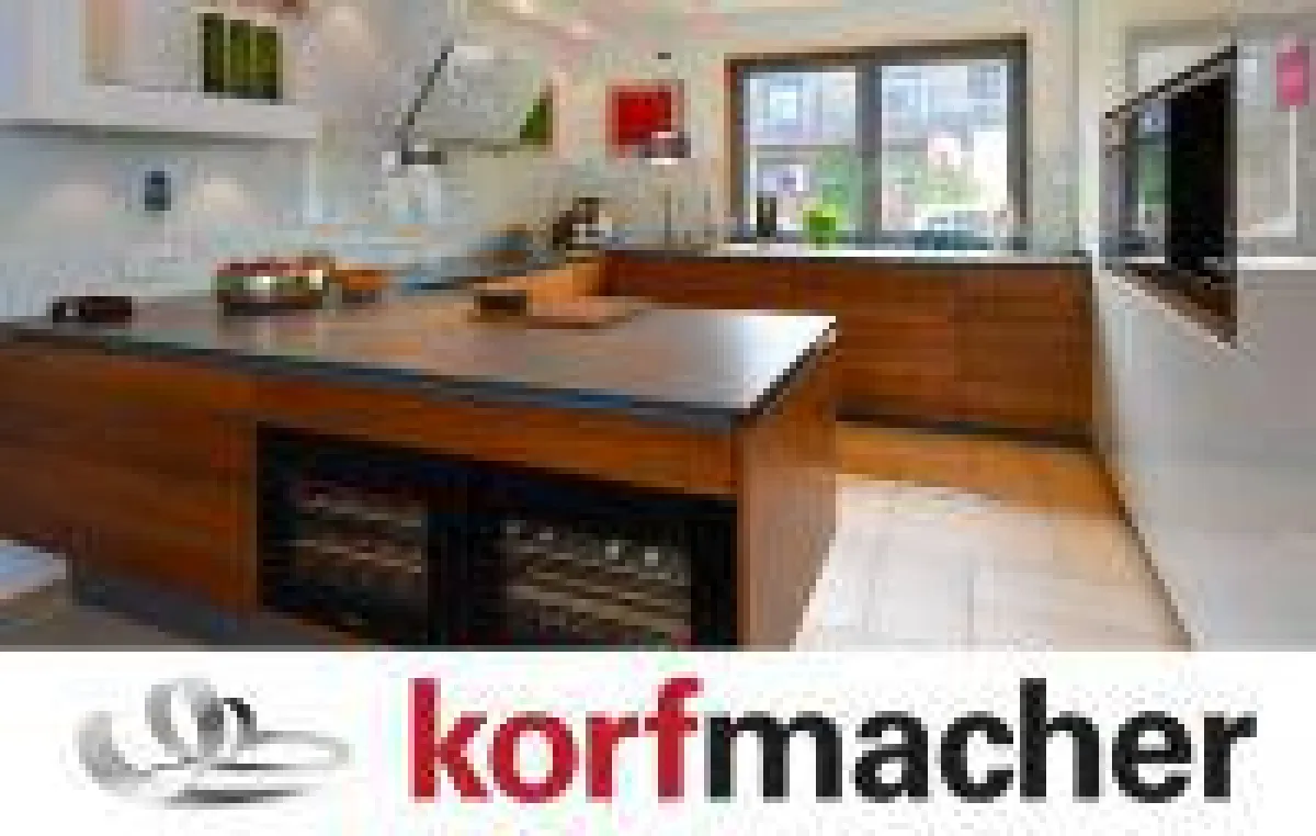 Traumküche mit grifflosen Fronten in Nussbaum massiv sowie aus weißem Glas (Hochschrank) und 12 mm dünner Keramik-Arbeitsplatte.