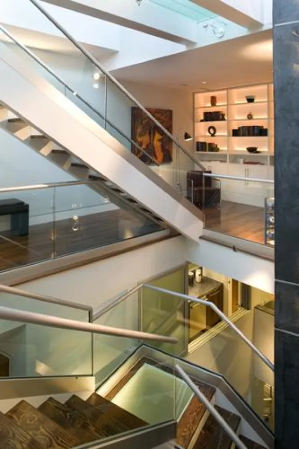 Im Zentrum des Atriums stellen die Treppe und der Lift die vertikale Verbindung der Ebenen dar.