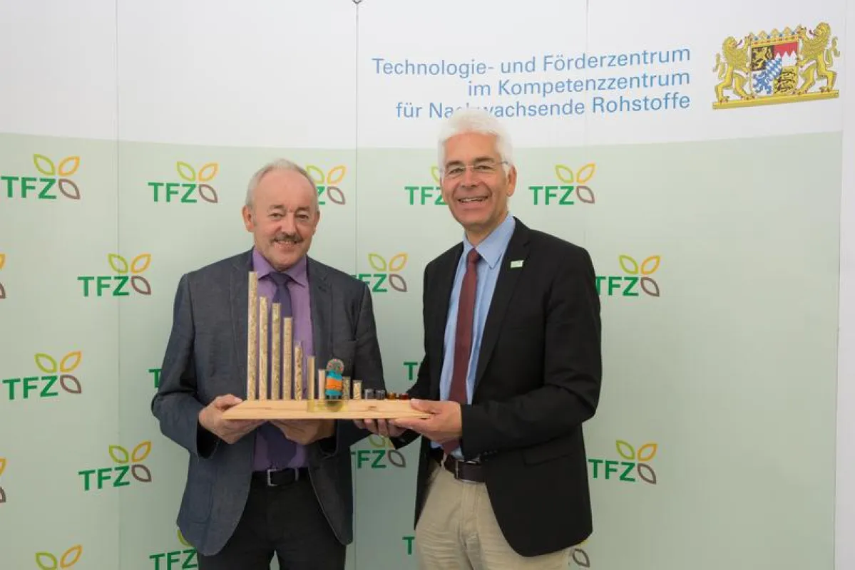 Dr. Widmann, Leiter des Technologie- und Förderzentrums (rechts) überreichte Franz Kustner eine TFZ-Brennstofforgel als Auszeichnung für sein jahrzehntelanges Engagement für Nachwachsende Rohstoffe (U