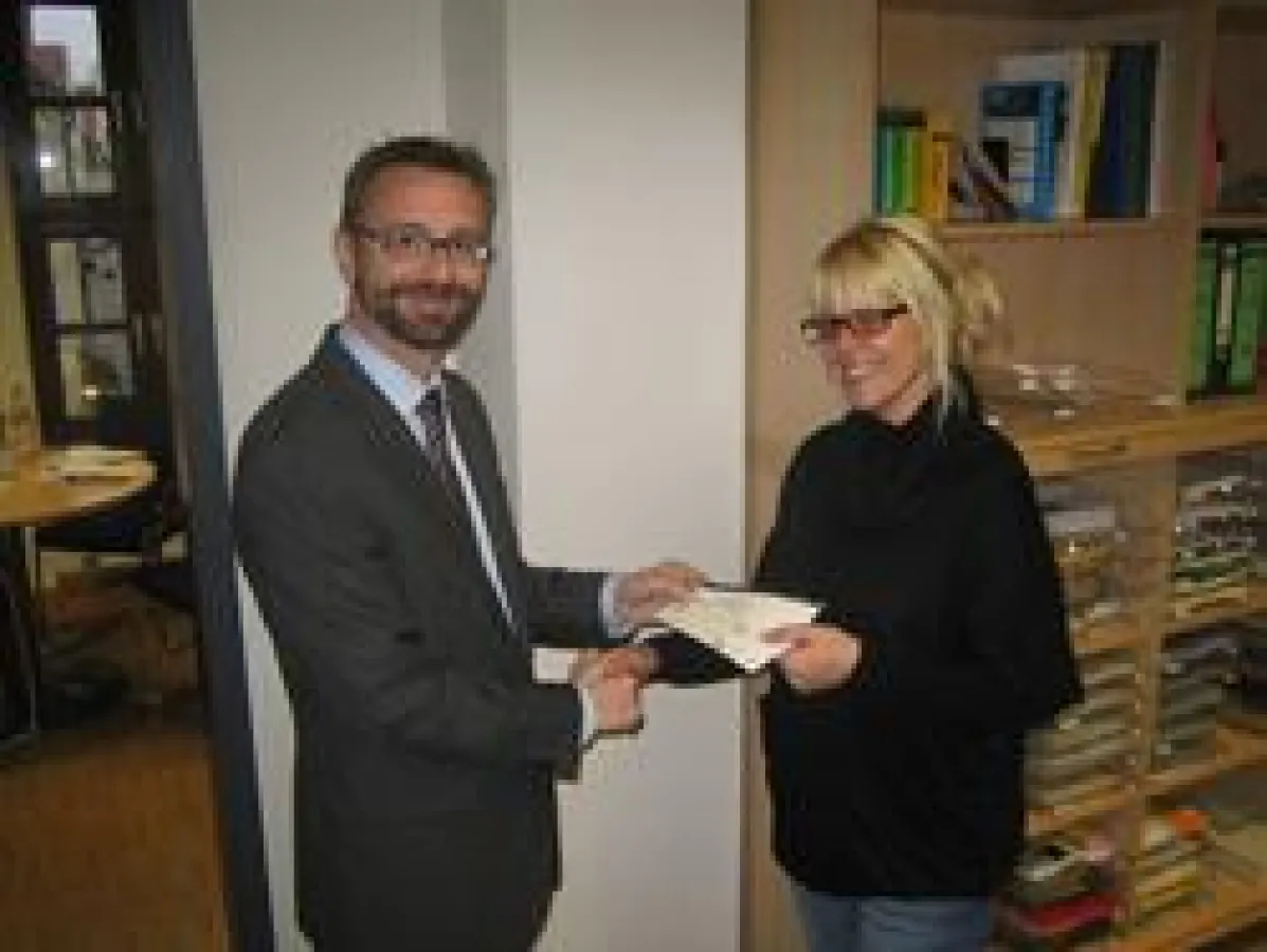 Dr. Jürgen Amann überreicht der glücklichen Gewinnerin 2 Tickets