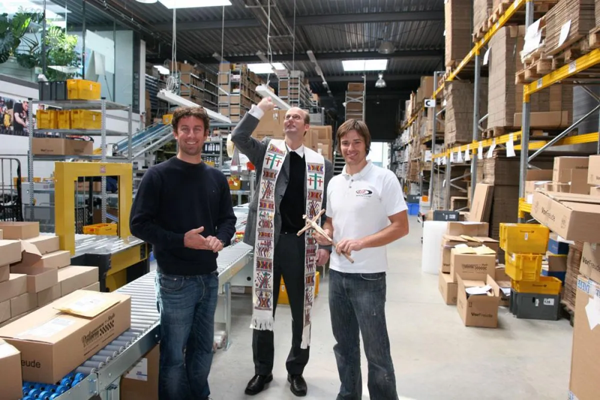Stadtpfarrer Rauch weiht die moderne Logistikanlage ein. Daneben (links) Ralf Jodl und (rechts) Alexander Barth, die Inhaber.