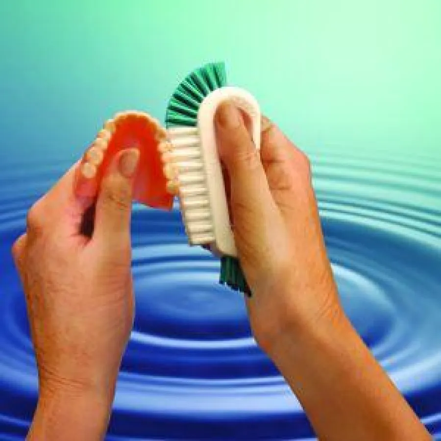 Mundhygiene gegen Parodontitis: Neuartige Prothesenbürste liegt optimal in der Hand und reinigt die Prothese einfach und gründlich - mit Wasser.