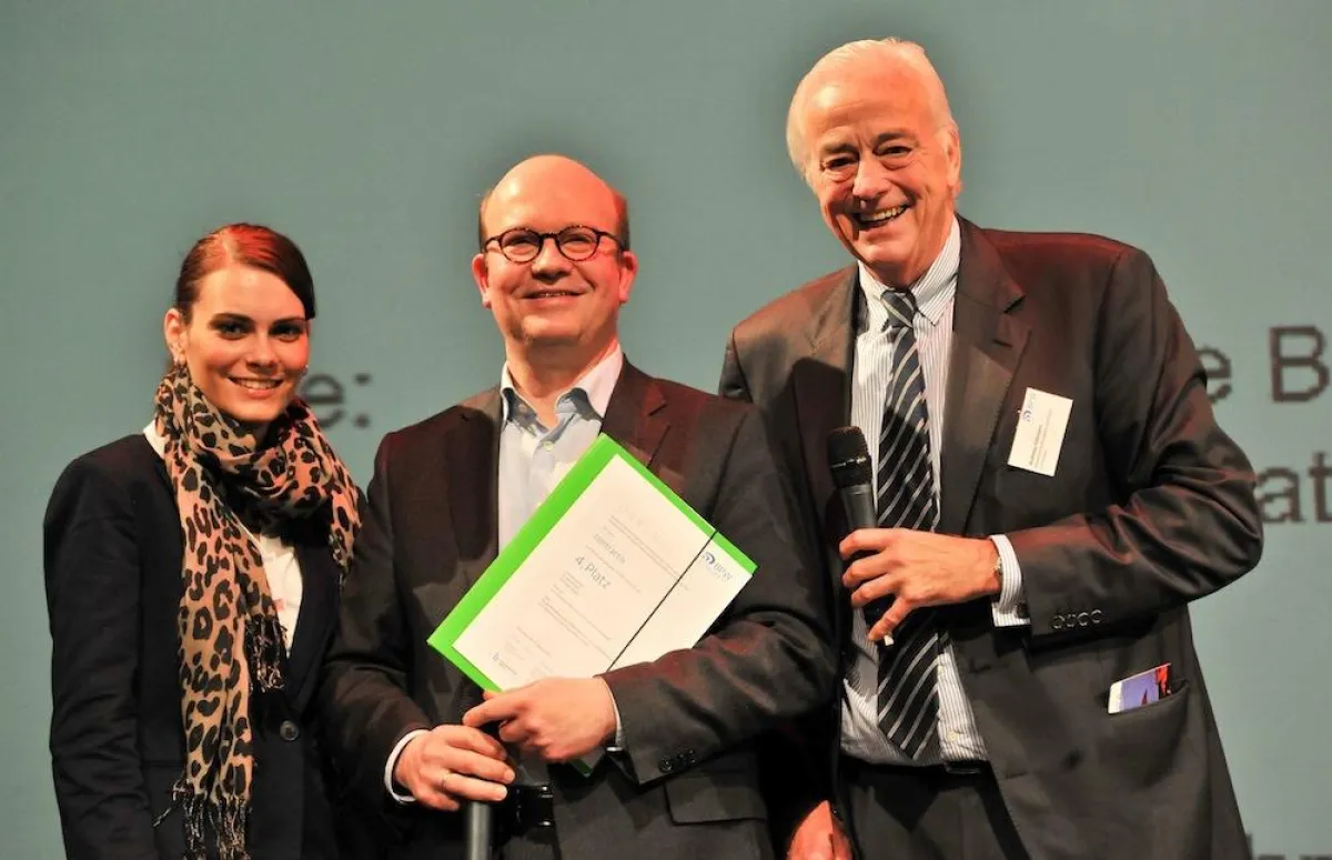 Anne Gradler (Online Marketing) und Dr. Harald Fett (Gründer) erhalten von Laudator Andreas Fellmann