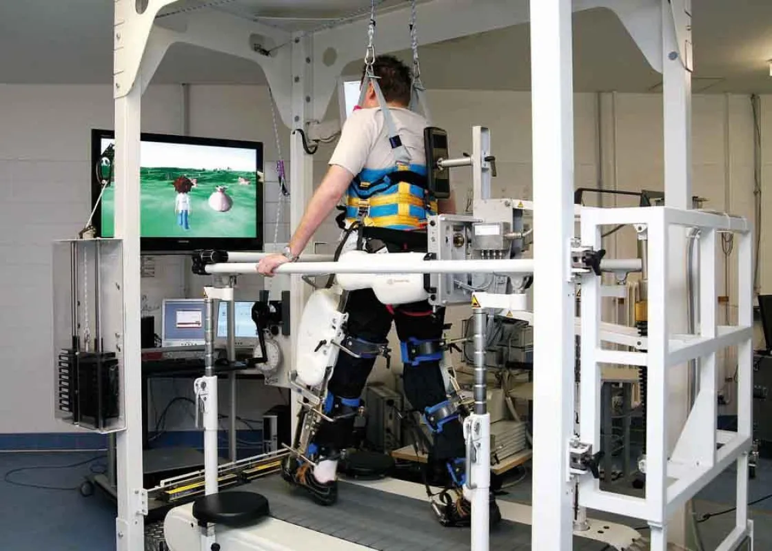 Ein Patient bei einer Therapieeinheit am erweiterten Lokomat® System: Die akustischen und virtuellen Einspielungen sollen den Patienten während seines Trainings motivieren.