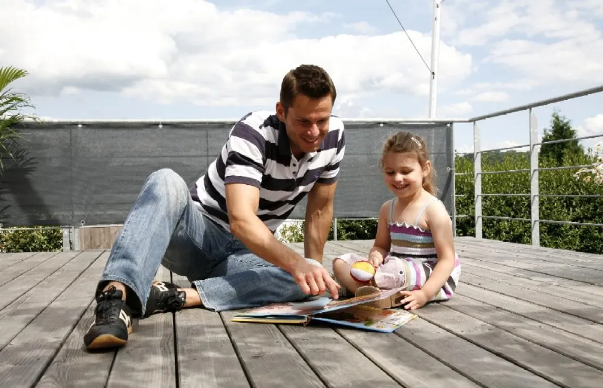 Eine Terrasse mit Holzbeplankung heizt sich auch bei starker Sonneneinstrahlung nicht auf. Ideal für lange Spielnachmittage im Freien.