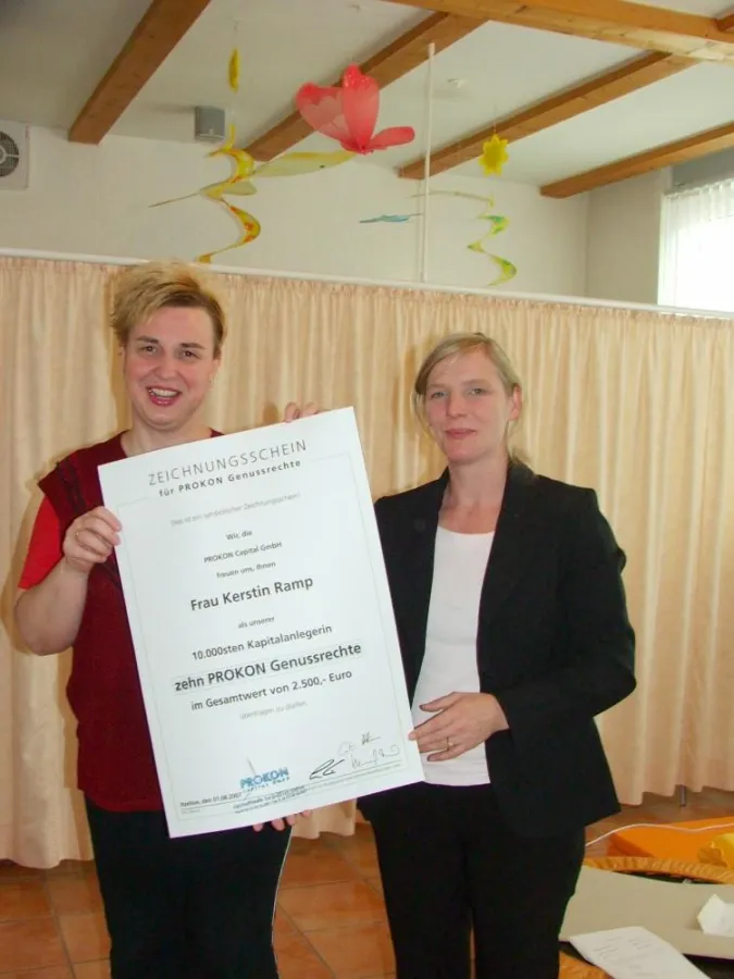 PROKON-Beraterin Bianca Berndt-Gronau überreicht symbolischen Zeichnungsschein über 2.500 Euro an 10.000ste PROKON-Anlegerin Kerstin Ramp aus Berlin.