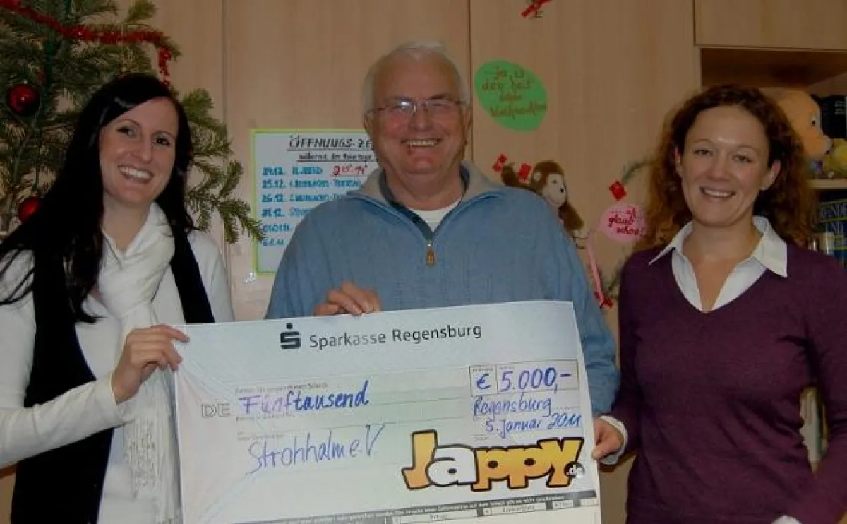 Carolin Wimmer (links) und Katharina Weinberger überreichen an Strohhalm-Chef Josef Troidl einen 5000-Euro-Scheck. Foto: Scherrer