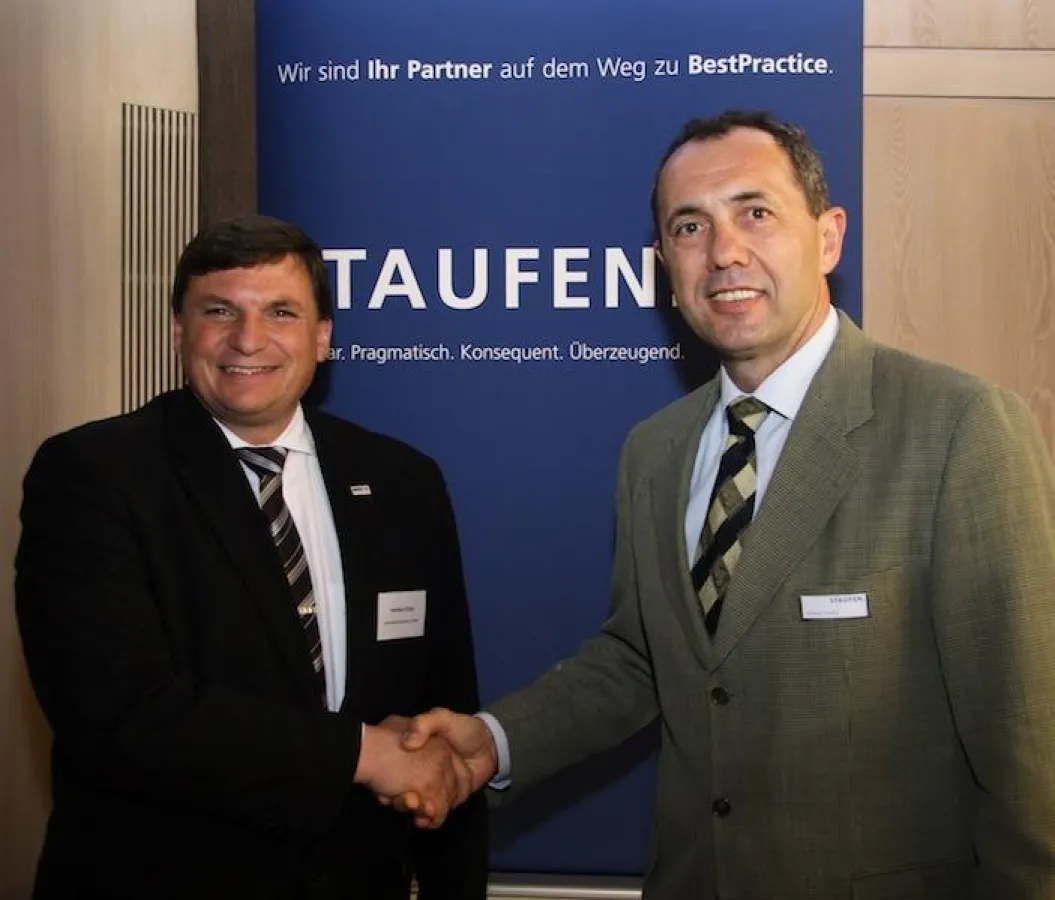 Herbert Klein, Werksleiter Peißenberg bei der Agfa-Gevaert HealthCare GmbH, und Wilhelm Goschy, Geschäftsfeldleiter bei der Staufen AG, besiegeln die Kooperation