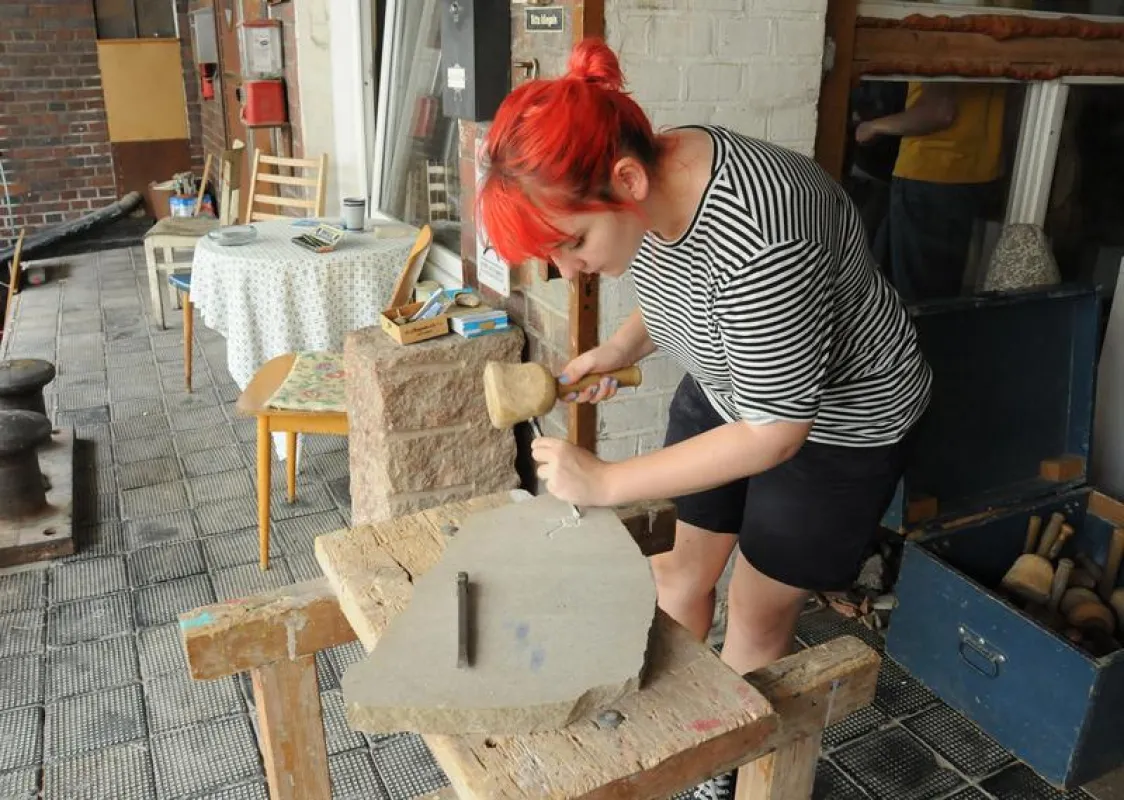 Wie in der Antike schlägt Eva Ruchti den Buchstaben „R“ mit Hammer und Meißel in eine Steintafel. ((Foto: Judith Küfner))