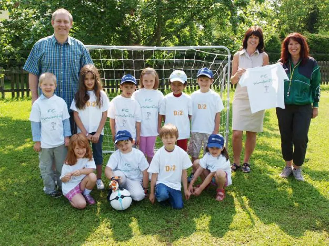 von links: Harald Hubrich (Di2 Ideenschmiede), 10 Spieler des FC Wunderfitz, Ines Walz (Leiterin Kindergarten Wunderfitz), Heike Brugger (Erzieherin und Trainerin Wunderfitz)